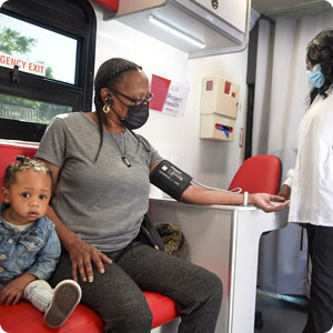 A Project Health screening of a woman with a child by her side