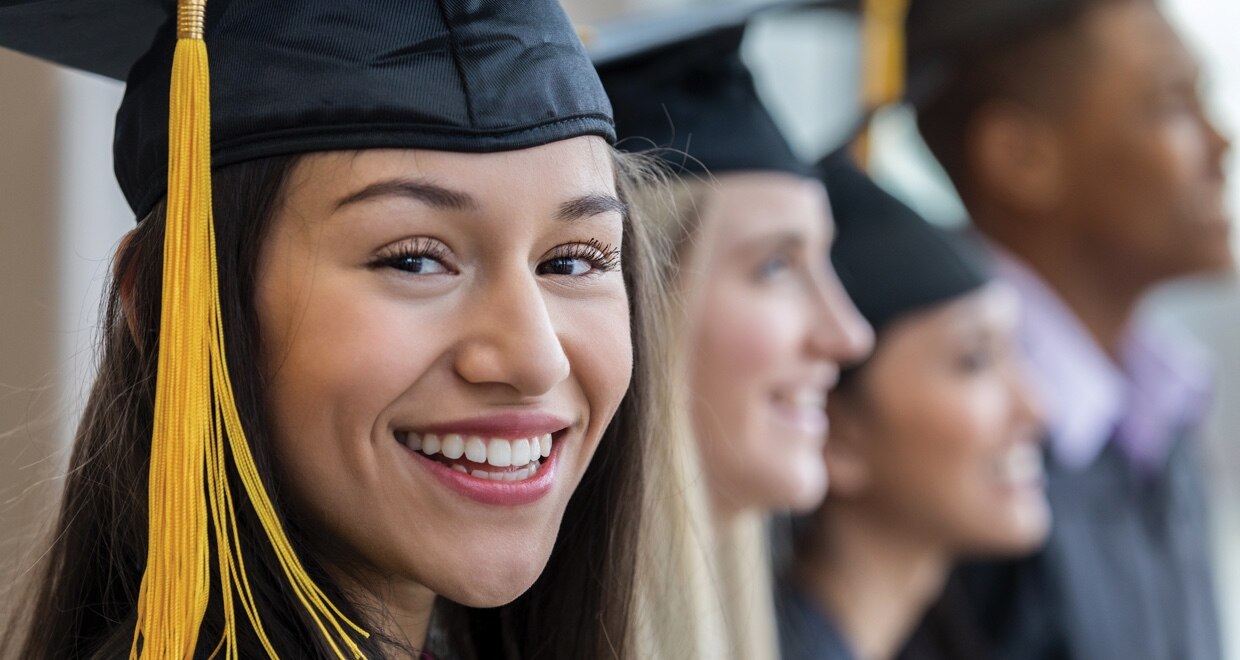 Girl in cap and gown smiling at graduation.