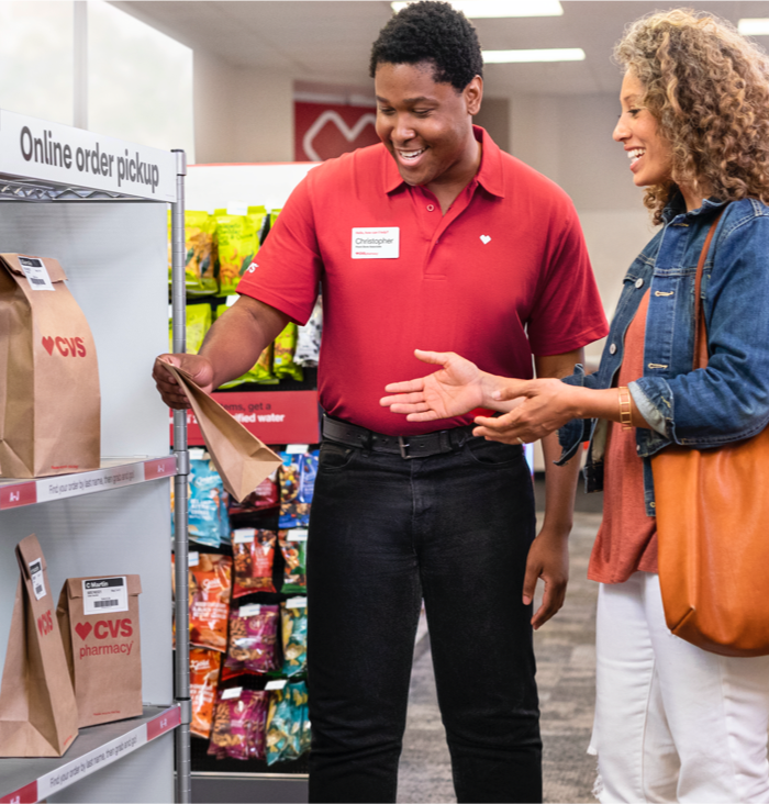 A CVS colleague assists a shopper with her pickup order.
