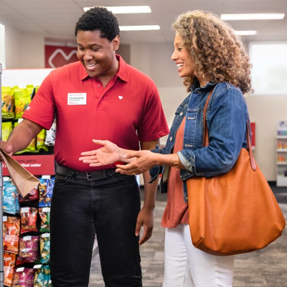 A CVS colleague assists a shopper with her pickup order.