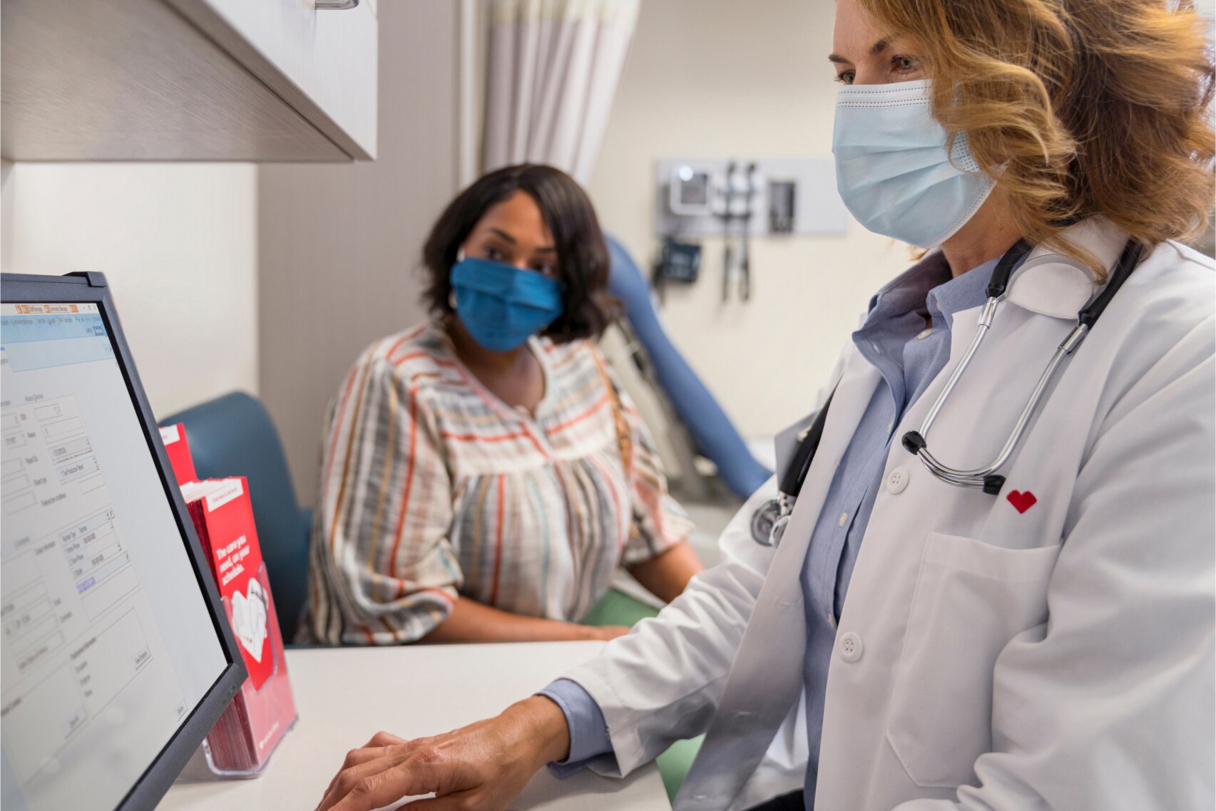 A MinuteClinic provider explaining diabetes monitoring numbers to her patient in a clinical setting.