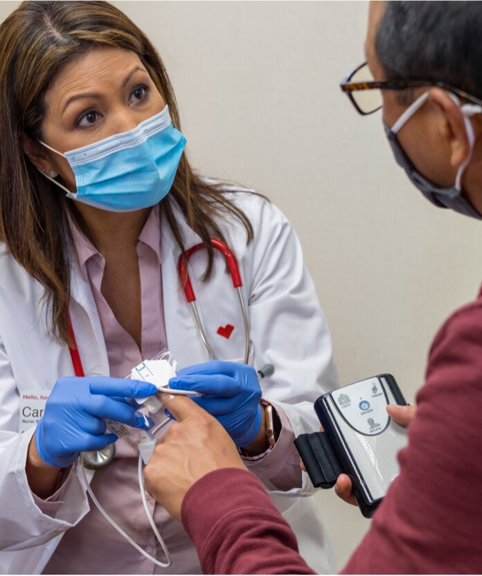 A health practitioner screens a patient for chronic conditions.