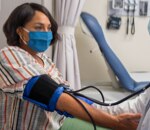 A woman has her blood pressure checked inside a HealthHUB.