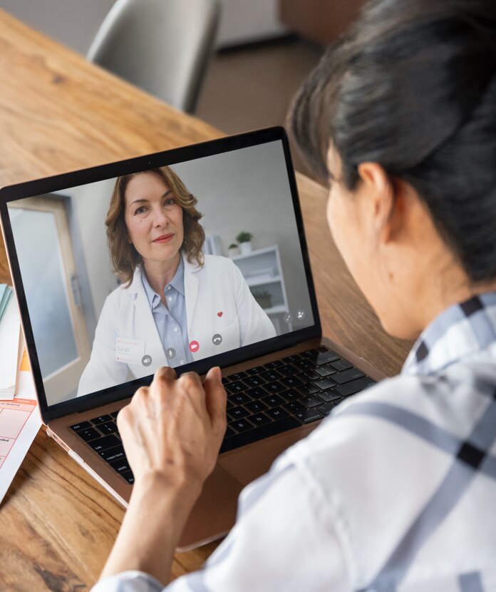 A woman takes a sleep assessment with a MinuteClinic provider on her laptop during a telehealth visit.