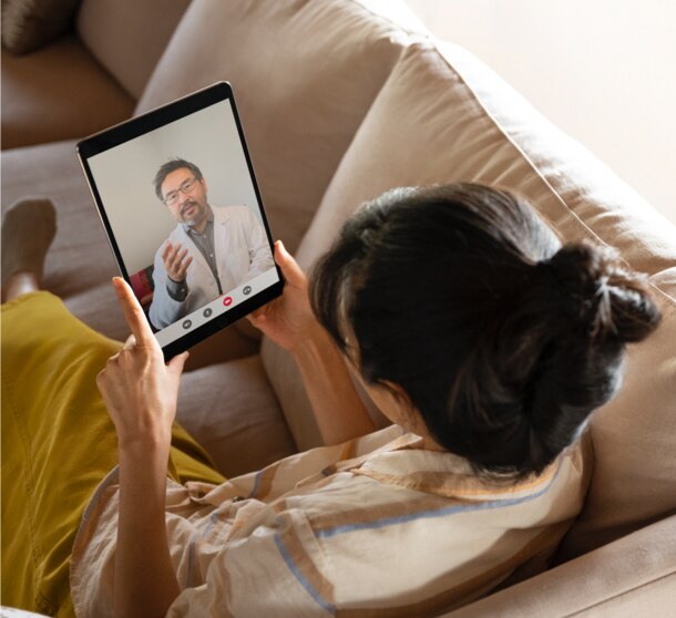 Mujer hablando con un terapeuta con licencia por tablet durante una sesión de terapia de telemedicina.