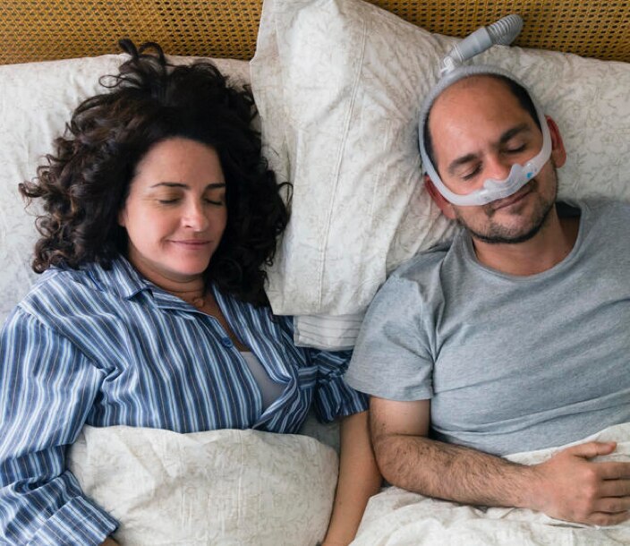 Una máquina de presión positiva continua de las vías respiratorias (CPAP) ayuda a un hombre con apnea obstructiva del sueño a dormir sin interrupciones.