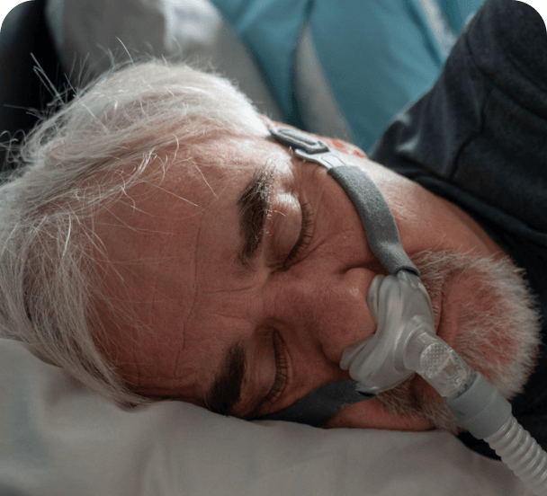 Man in bed using a CPAP device