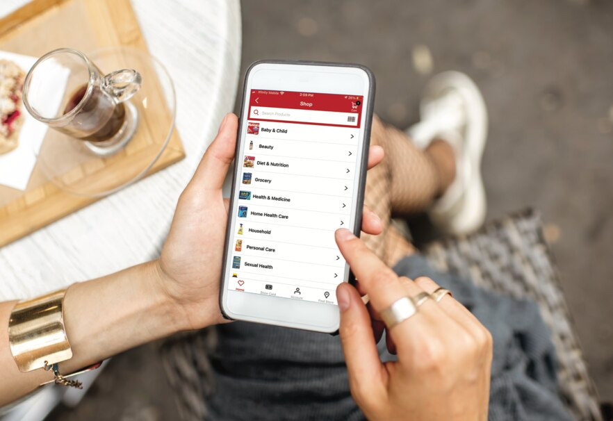 A person browsing through shopping categories on the CVS app via a handheld device. Shop now.