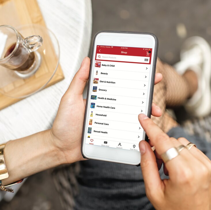 A person browsing through shopping categories on the CVS app via a handheld device. Shop now.