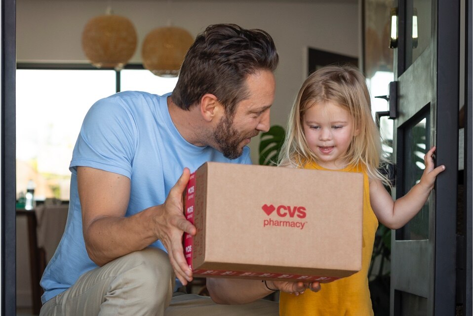 Picture of man with little girl holding a CVS delivery box.