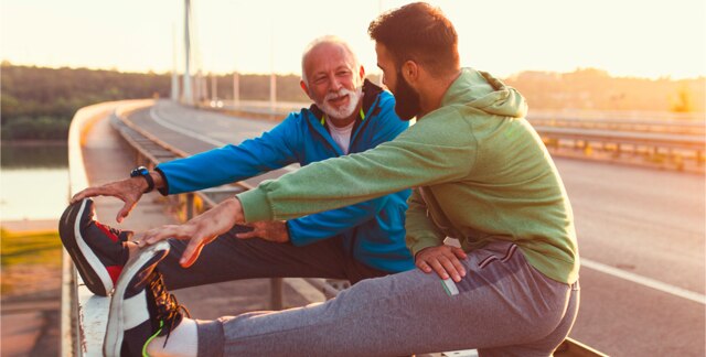 Older father and son stretching aside a road