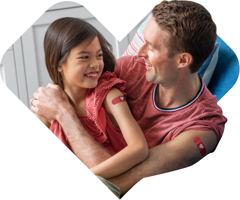 A father and daughter with CVS bandages on their arms from being vaccinated