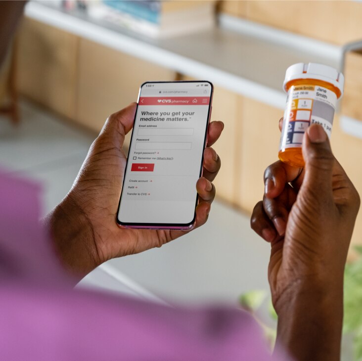 Cliente de CVS usando su dispositivo móvil para iniciar sesión y buscar ahorros en medicamentos recetados.