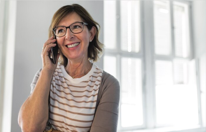 A caregiver calls her loved one on the phone.