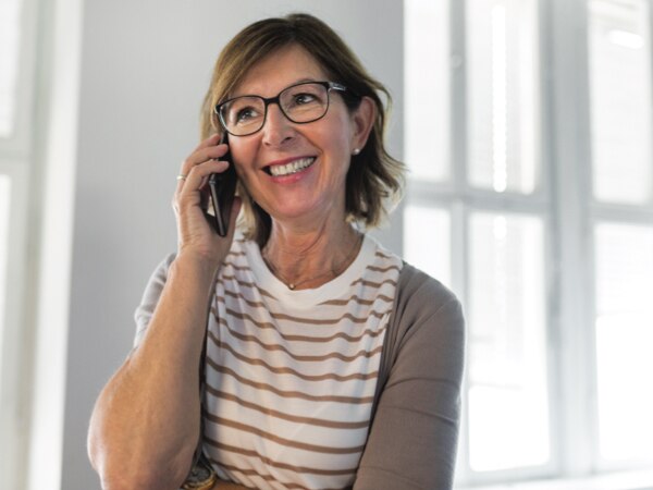 A caregiver calls her loved one on the phone.