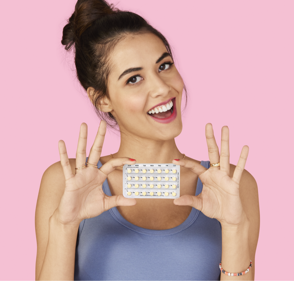 Mujer sonriendo y sosteniendo un paquete de píldoras anticonceptivas.