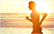 Photo of man running on the beach.