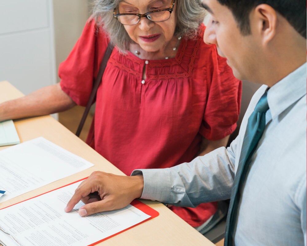 Asesor de Medicare explicando las opciones de planes a una persona mayor