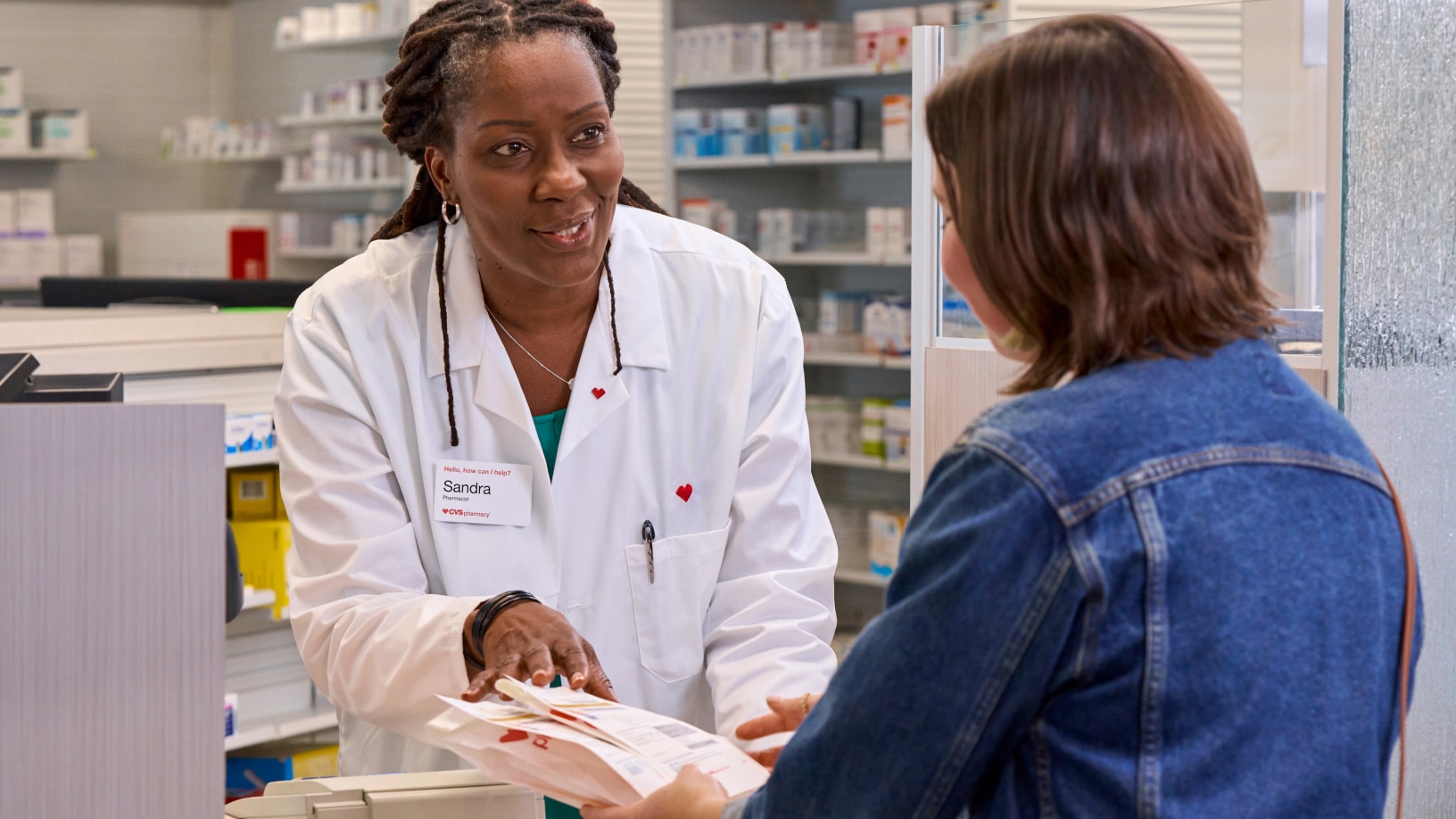 A CVS pharmacist explains prescription information for a customer.