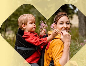 A parent hands flowers to their child during a hike.