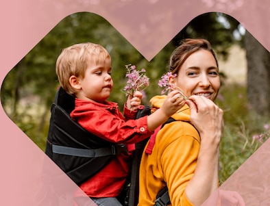 A parent hands flowers to their child during a hike.