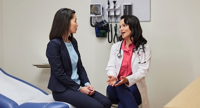 A patient speaks with her provider during a health screening.
