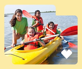 A camp counselor teaches kids to kayak.