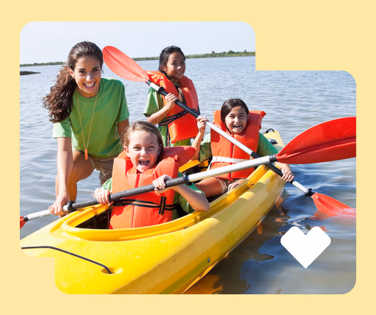 A camp counselor teaches kids to kayak.