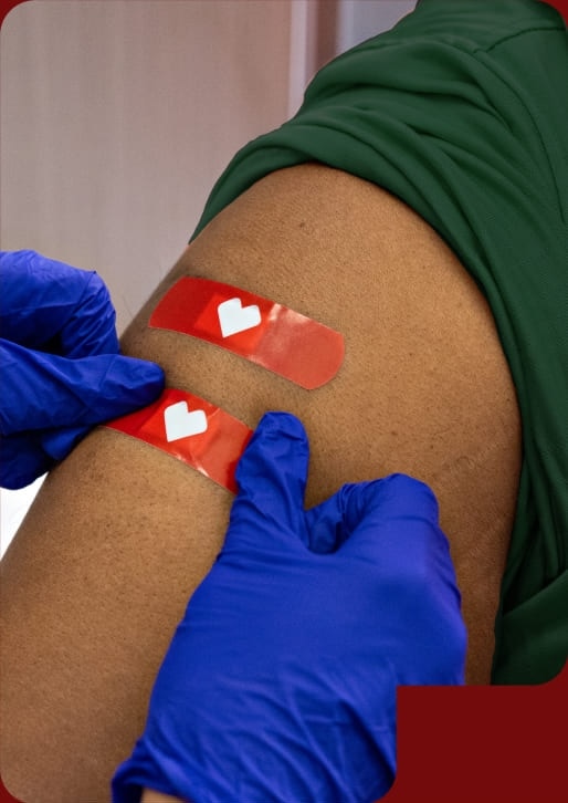 Pague $10 menos en compras de $20 después de la vacunación. Se aplican restricciones. Un profesional en vacunación certificado coloca una banda adhesiva en el brazo de una persona después de administrar la vacuna.