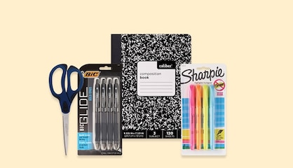 Back-to-school supplies, including scissors, pens and a composition notebook.