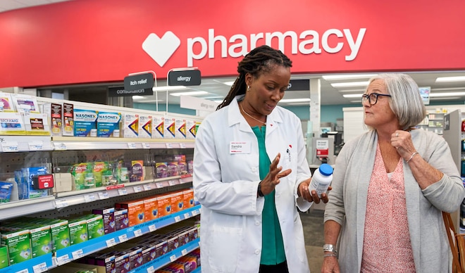 Un profesional en farmacia explica un medicamento a un paciente dentro de una tienda CVS.