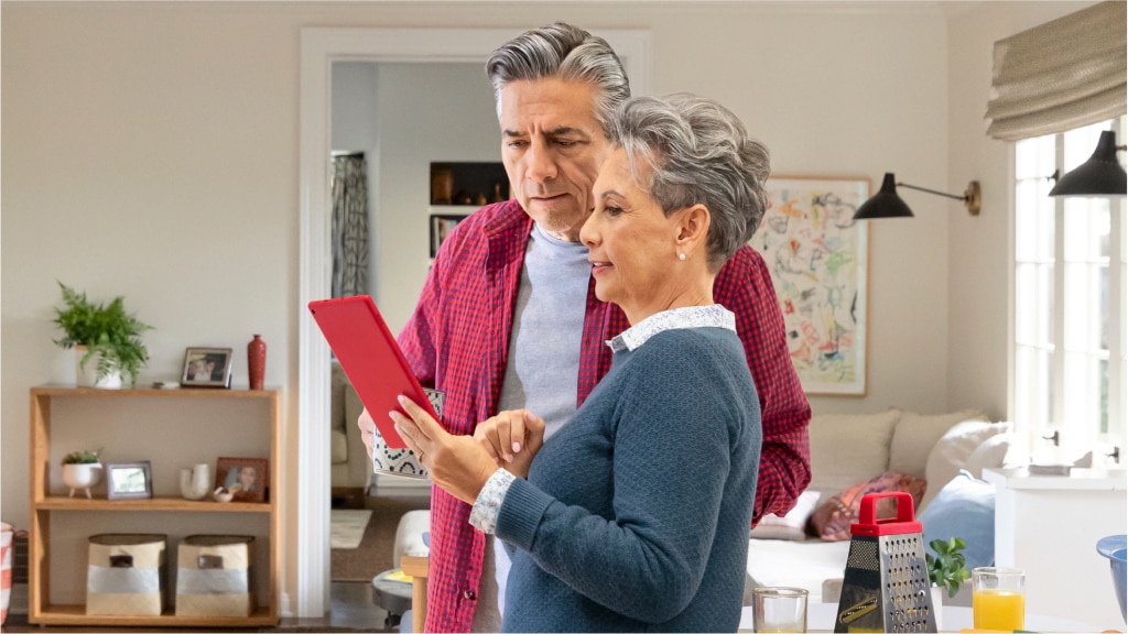 An older couple reviews their vaccine history online.