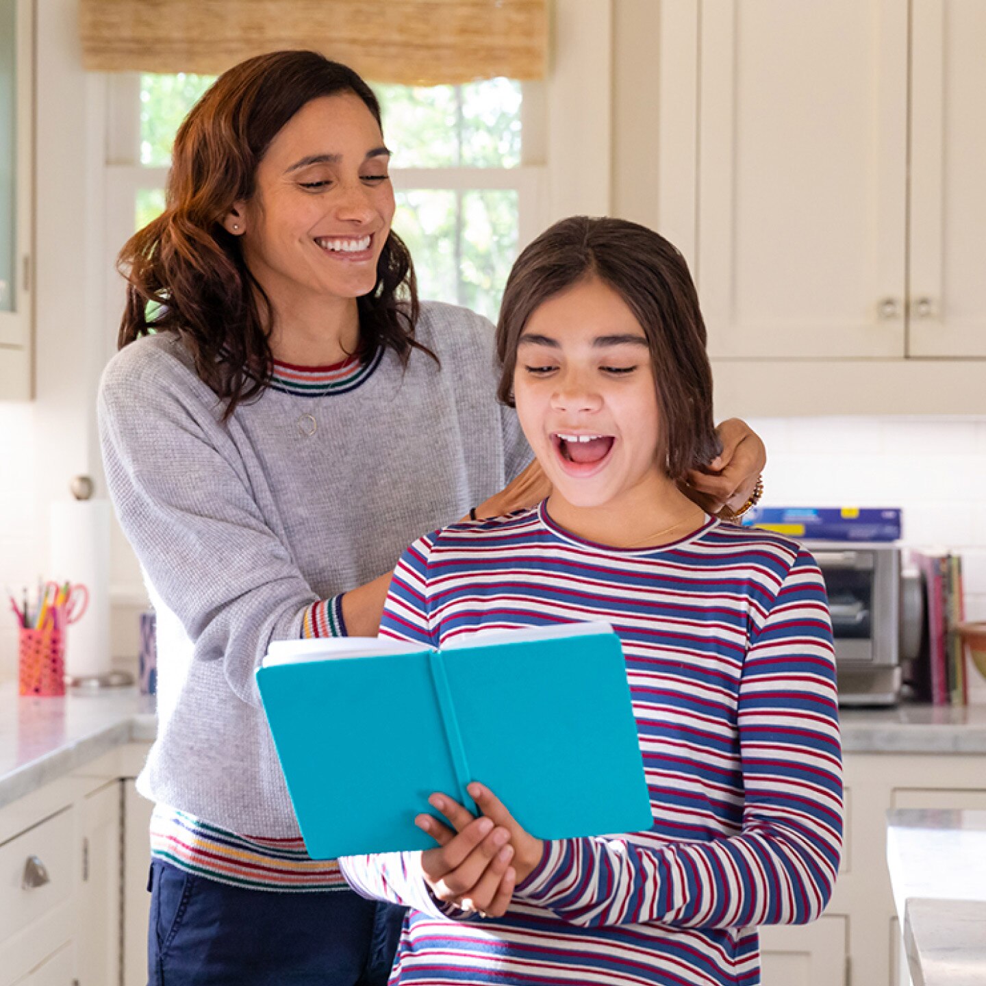 A mother and daughter spend time together in their family kitchen.