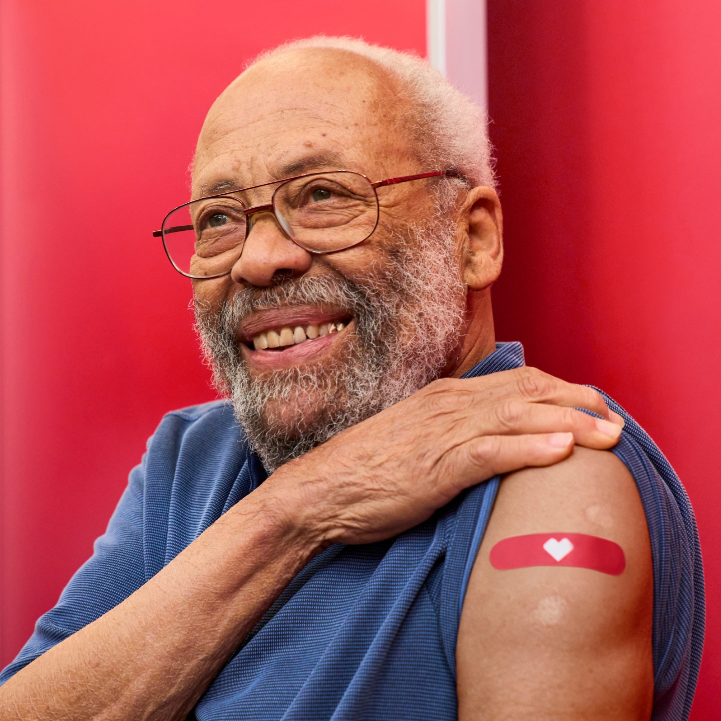 Hombre mayor levantándose la manga para mostrar una venda de CVS en un centro de vacunación contra el VRS.