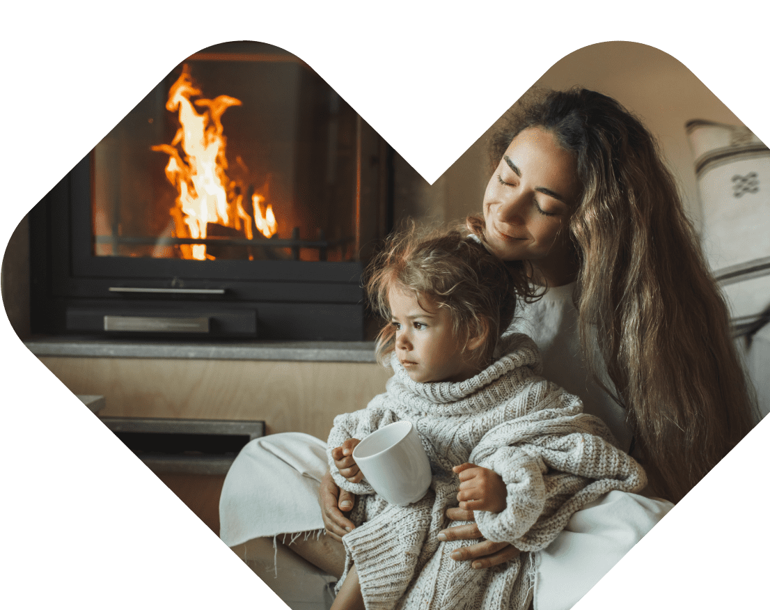 A mother and child spend time together by an open fire.