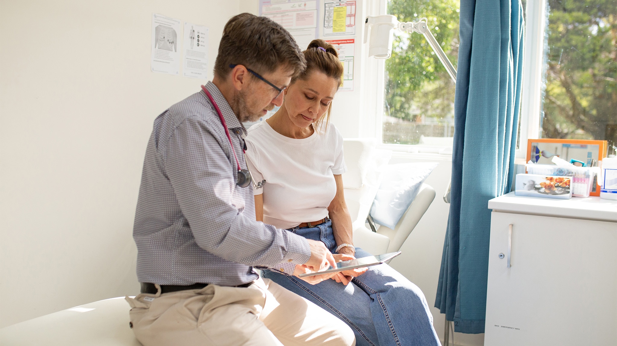 Male doctor explains results to female patient during a doctor's appointment.