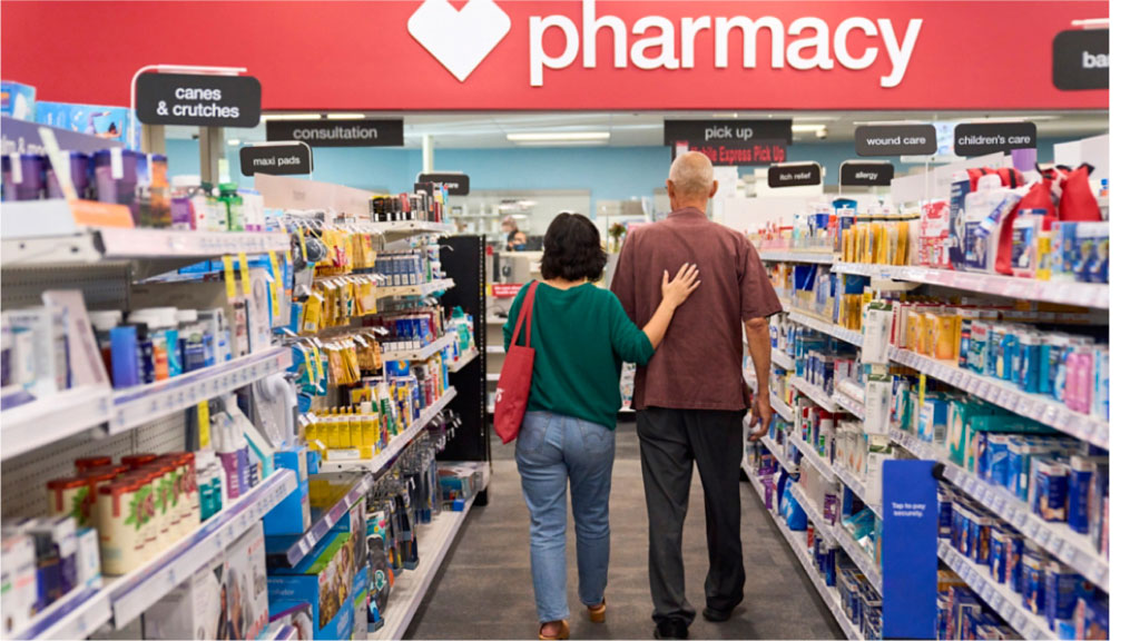 Una pareja mayor camina por el pasillo de una farmacia CVS.