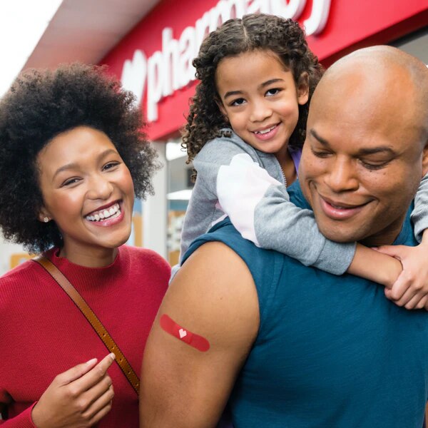 Happy family all with red CVS bandages on arms after receiving flu shots