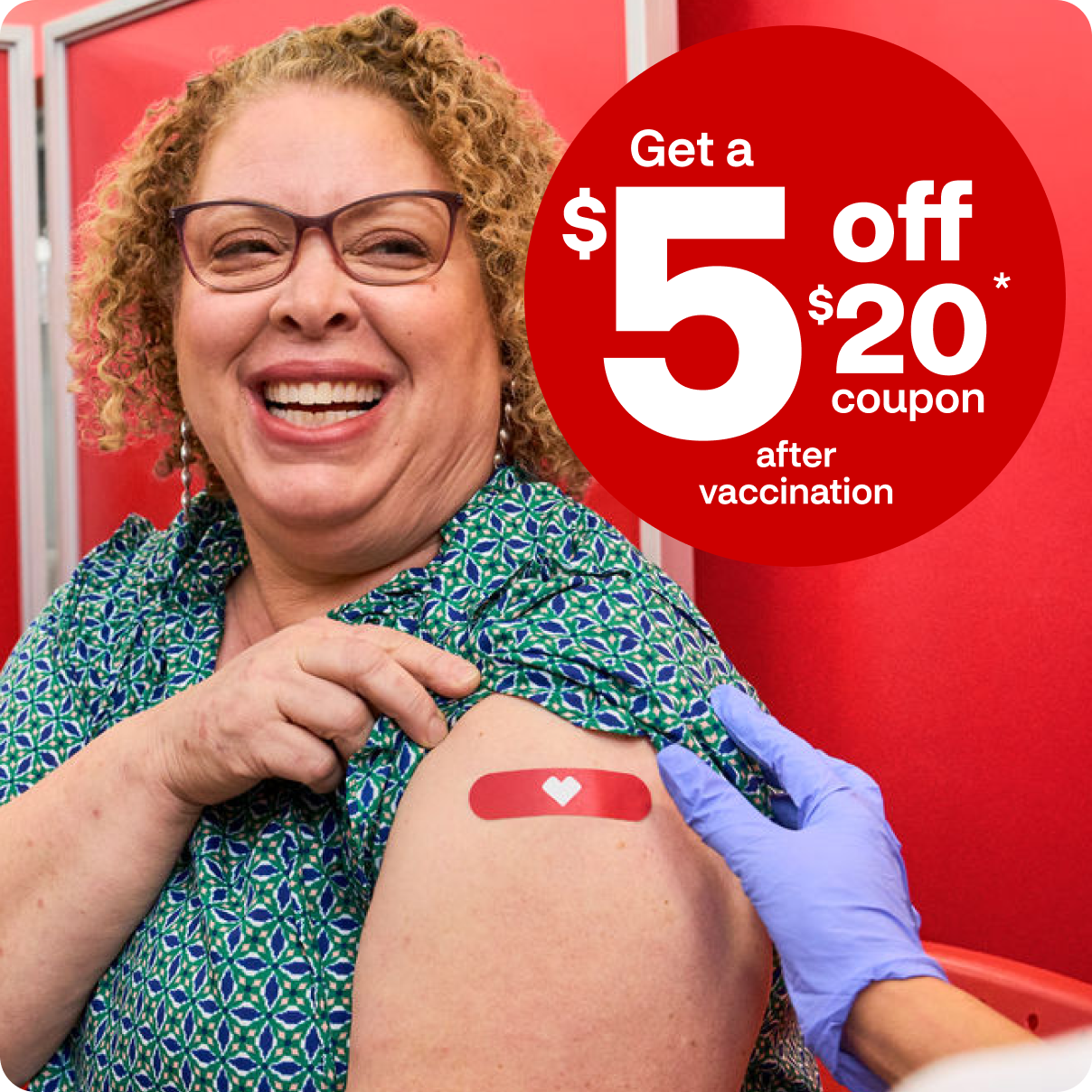 A smiling woman receives her flu shot at CVS.