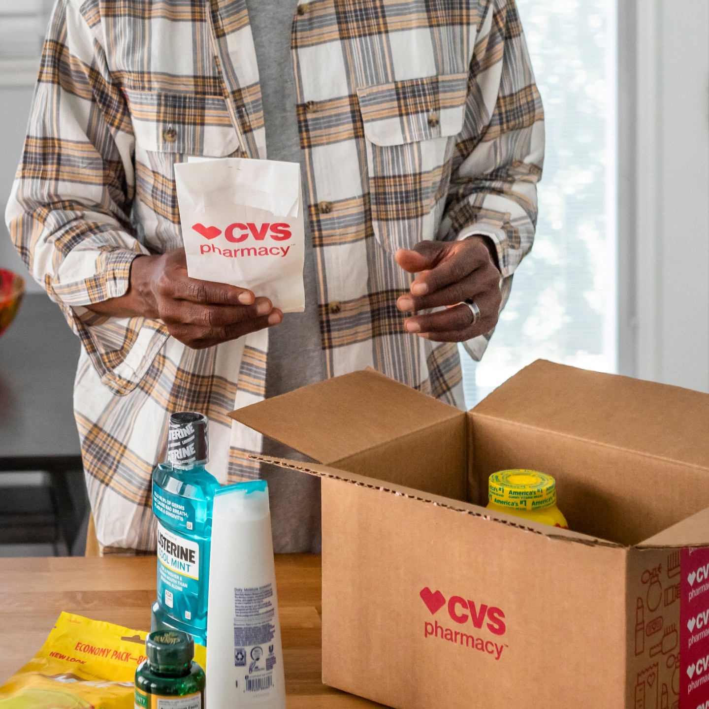 A father unpacks his prescription from a CVS delivery box